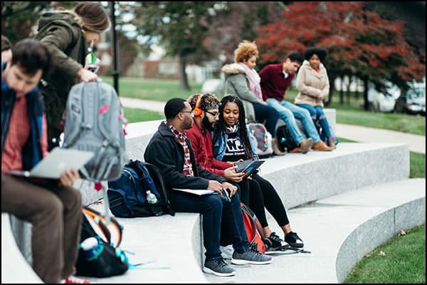Students sitting in the outdoor classroom, chatting after class